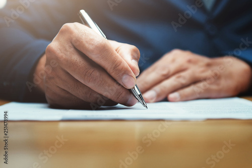 Fotografía businessman writing on paper report in office