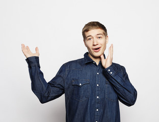 Wall Mural - Portrait of a smart young man standing against white background