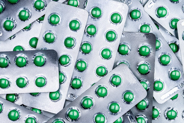 Wall Mural - Closeup pile of round green sugar coated tablet pill in blister pack. Combine pill for relief cough. Pharmaceutical product. Pharmaceutical industry. Pharmacy background. Medicine for dry cough.