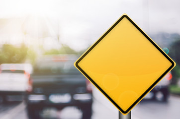 Wall Mural - Empty yellow traffic sign on blur traffic road with colorful bokeh light abstract background.