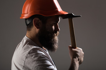 Wall Mural - Builder in helmet, hammer, handyman, builders in hardhat. Bearded man worker with beard, building helmet, hard hat. Hammer hammering. Handyman services. industry, technology, builder man, concept.