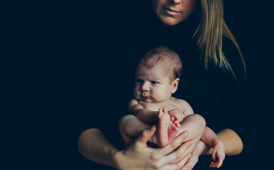 Nude baby posing in her mother's arms