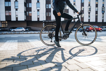 Midsection of male courier with bicycle delivering packages in city. Copy space.