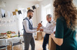 © Halfpoint - A man giving a bottle of wine to his father on indoor birthday party, a celebration concept.