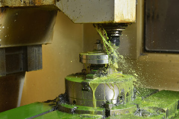 Spindle chuck and installed metal part in pocessing on high precision Cnc industrial lathe turning machine. CNC machine cuts off excess edges on metal part