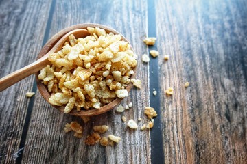 Close up of dried rice snack on wooden bowl. 