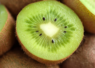 Wall Mural - Slices of kiwi fruit on kiwi background