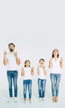 Beautiful Family Standing In Line And Pointing Up And Shouting Isolated On White Background