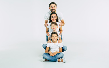 Happy cute smiling family looking on camera isolated on white studio