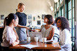 © Monkey Business - Businesswomen Paying Bill At Meeting Around Table In Coffee Shop