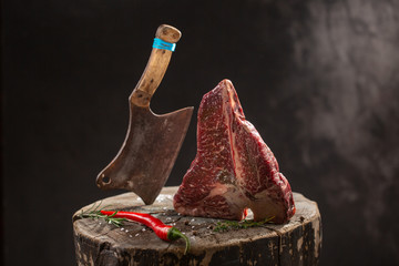 Wall Mural - Raw Fresh Marbled Meat Beef ax on a black background.