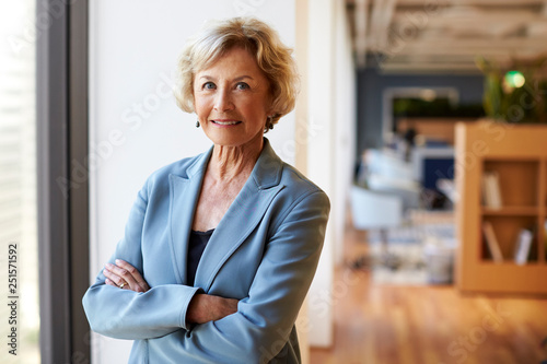 Photographie Portrait Of Smiling Senior Businesswoman In Modern Office Standing By Window