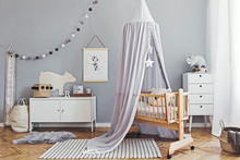 Stylish And Cute Scandinavian Decor Of  Newborn Baby Room  With Mock Up Poster , White Design Furnitures, Natural Toys, Hanging Grey Canopy With Wooden Cradle, Pillows, Accessories And Teddy Bears. 