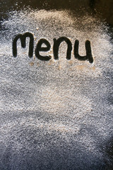 menu spelled in flour on a black granite surface restaurant cook bake chef