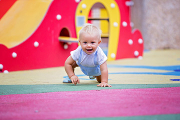 Sticker - Adorable baby boy, playing with different rides on the playgdorund