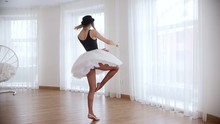 Young Beautiful Woman Ballerina Training In Bright Studio. Performing The Pirouette