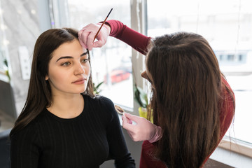 Make up artist applying make up for brow to a fashion model