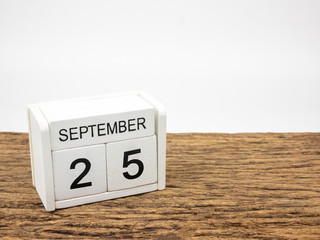 September 25 white cube wooden calendar on vintage wood and white background with autumn day, Copyspace for text