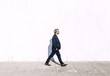 © Snapwire - Side view of man walking on sidewalk