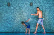 © Snapwire - Father and son playing with water in an open shower