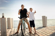 © Erickson Stock - Portrait of a smiling father and his son with a bicycle on a wharf.