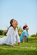 © Erickson Stock - Serene mid adult women practicing yoga in a serene green park.