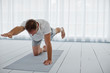 © Erickson Stock - Middle aged man stretching his arms and legs while practicing yoga.