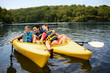 © Erickson Stock - Happy family kayaking on a lake.