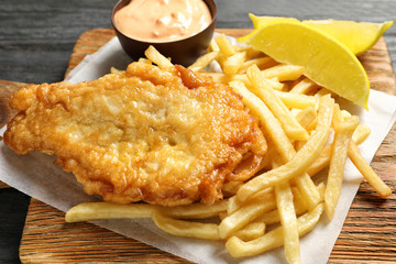 British traditional fish and potato chips on wooden board, closeup