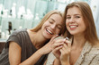 © Zoriana - Front view of happy woman keeping in hands new wonderful ring in jewelry store. Young client looking at camera and smiling while her female friend leaning on her and hugging. Concept of happiness.