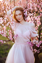 Beautiful Young Girl Under The Flowering Pink Spring Tree
