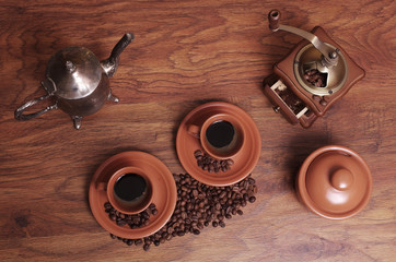 Two cups of coffee, coffee grinder, notebook, pen and rosehip flower