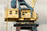 Fototapeta Miasto - Old heavy harbor jib crane in seaport.