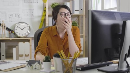 Wall Mural - slow motion tired woman architect lack of sleep working in morning office using computer with 3d miniature house model and blueprint on desk. girl interior designer in glasses feeling bored exhausted