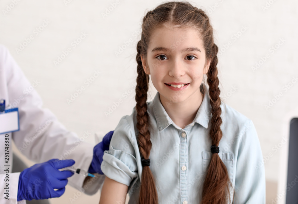 Doctor vaccinating child against flu in clinic