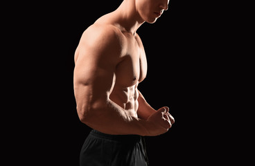 Wall Mural - Muscular bodybuilder on dark background