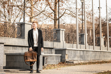 Wall Mural - Handsome businessman with stylish briefcase on city street