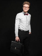 Wall Mural - Handsome businessman with stylish briefcase on dark background