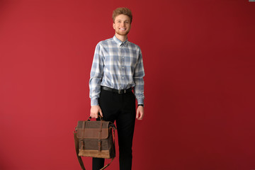 Wall Mural - Handsome man with stylish briefcase on color background