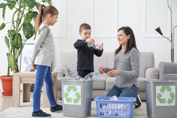 Family sorting garbage at home. Concept of recycling