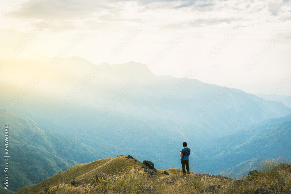 Instagram filter young man Asia tourist at mountain is watching over the misty and foggy morning sunrise, travel Trekking - obrazy, fototapety, plakaty 