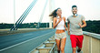 © NDABCREATIVITY - Athletic young cute couple jogging together outdoors