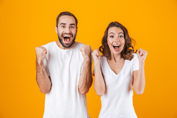 Sticker - Image of ecstatic people man and woman in basic clothing laughing, while standing together isolated over yellow background