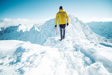 A climber ascending a mountain in winter