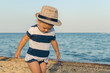 © andrei310 - Little girl in a hat walks along the seashore