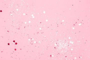 Wall Mural - Pink confetti and stars and sparkles on pink background. Top view, flat lay. Copyspace for text. Bright and festive holiday background. For Christmas, New year, Mother's day.