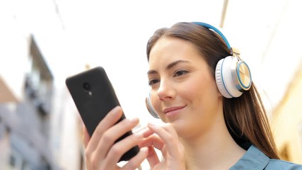 Wall Mural - Woman listening to music checking songs