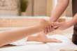 © LIGHTFIELD STUDIOS - cropped view of masseur doing foot massage to woman