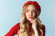 Portrait Of Elegant Blond Woman 20s Wearing Red Beret Looking Aside While Standing, Isolated Over Blue Background In Studio
