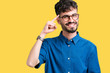 © Krakenimages.com - Young handsome man wearing glasses over isolated background Smiling pointing to head with one finger, great idea or thought, good memory